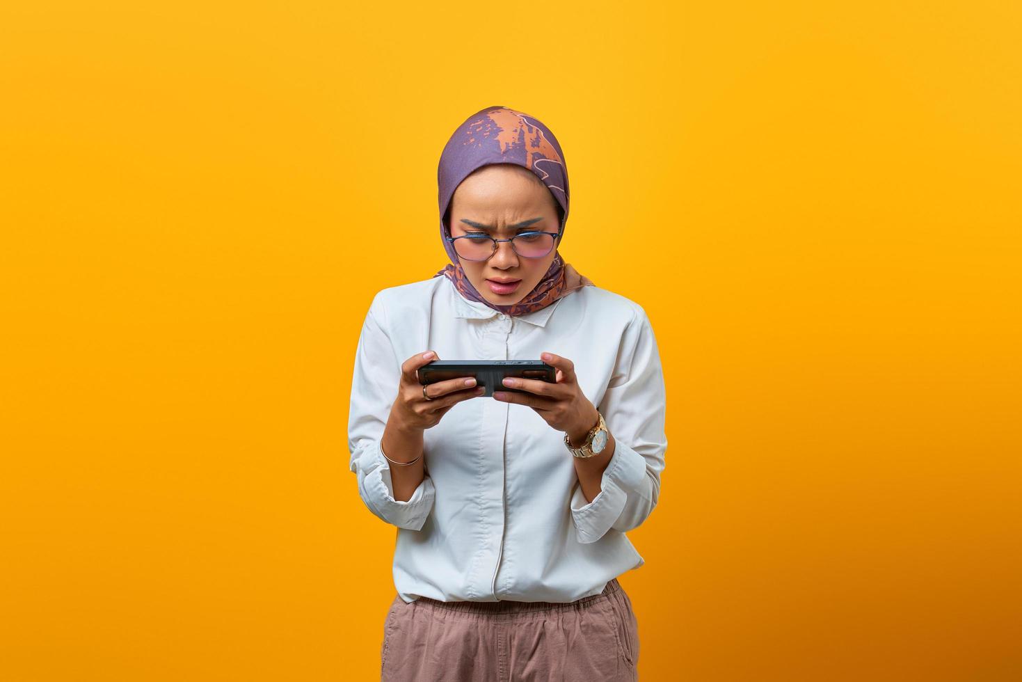 Hermosa mujer asiática con teléfono móvil jugando al juego foto