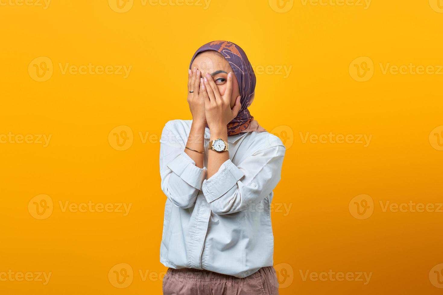 Beautiful Asian woman hidden palms face look about her mistake photo