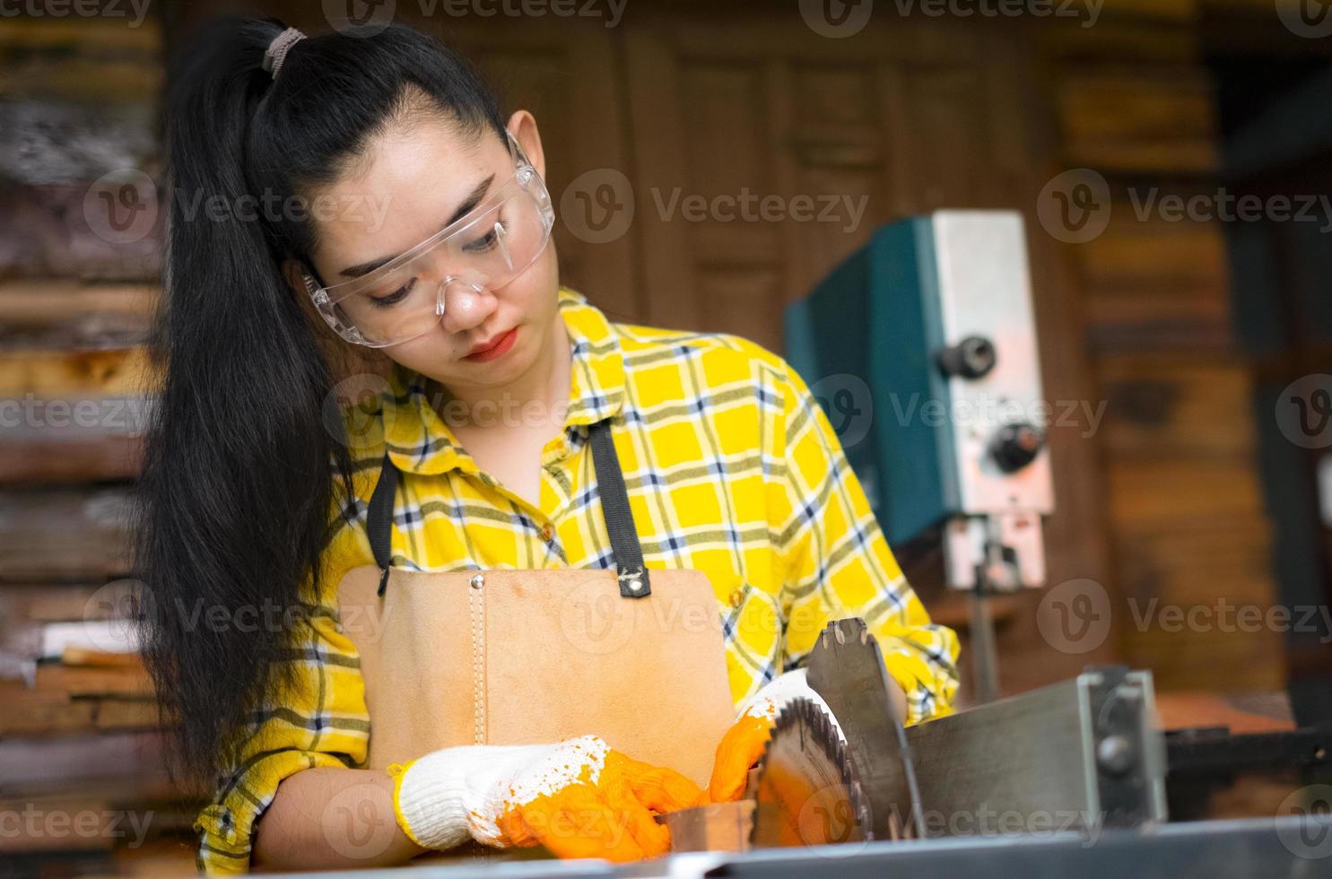 La mujer es artesanía trabajando madera cortada con sierras circulares herramientas eléctricas foto