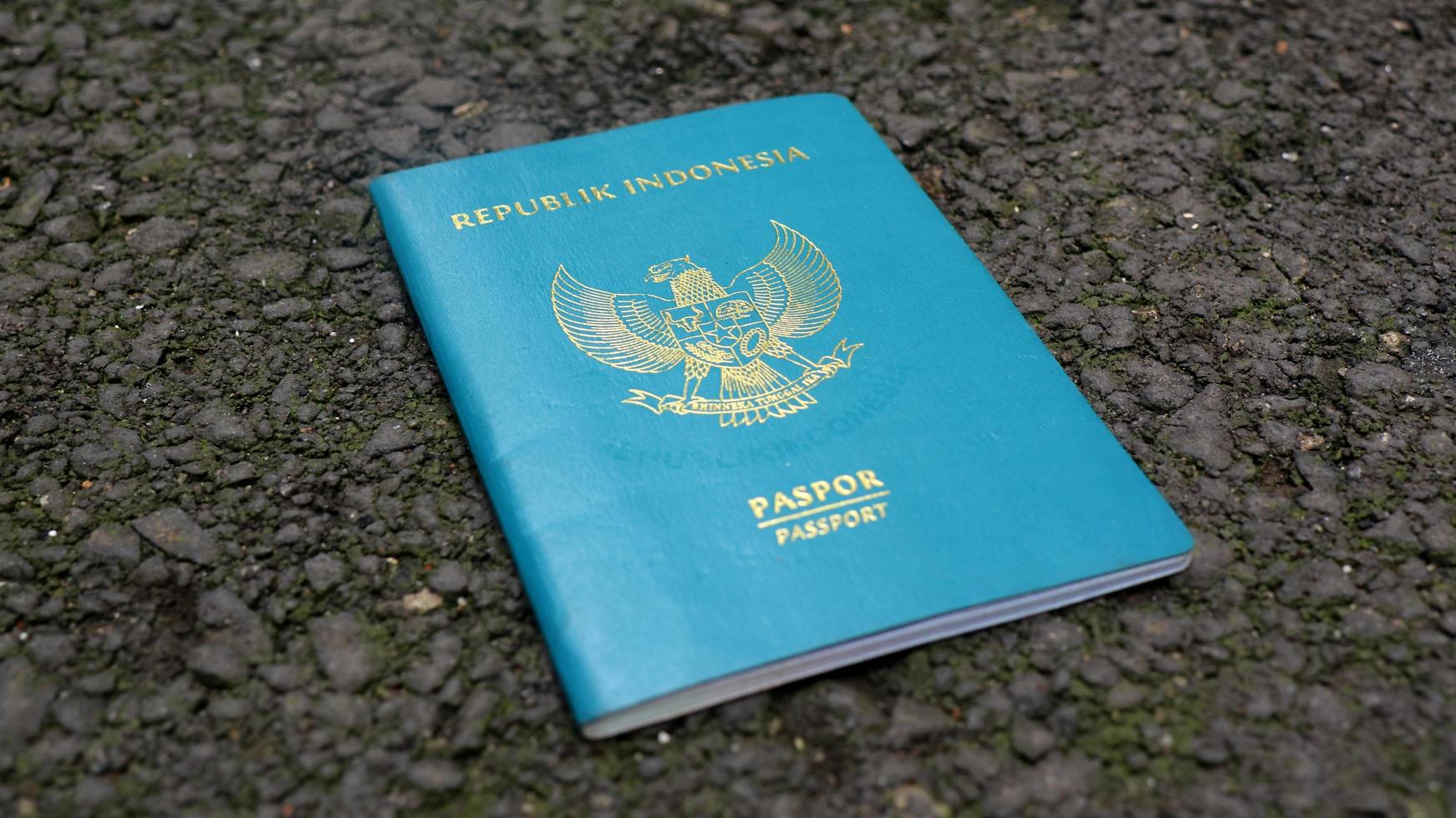 Libro de pasaportes de la República de Indonesia, aislado sobre suelo de asfalto foto