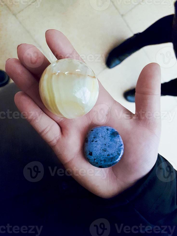 Girl holds blue yellow stones and minerals in her hand. photo