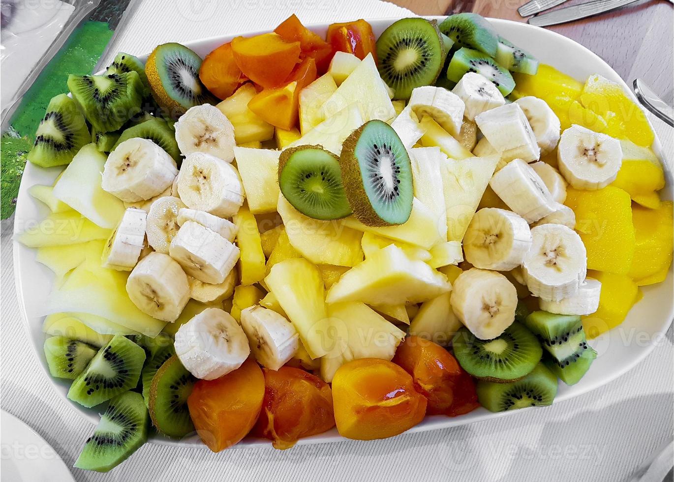 fruta colorida cortada y servida en un plato. foto