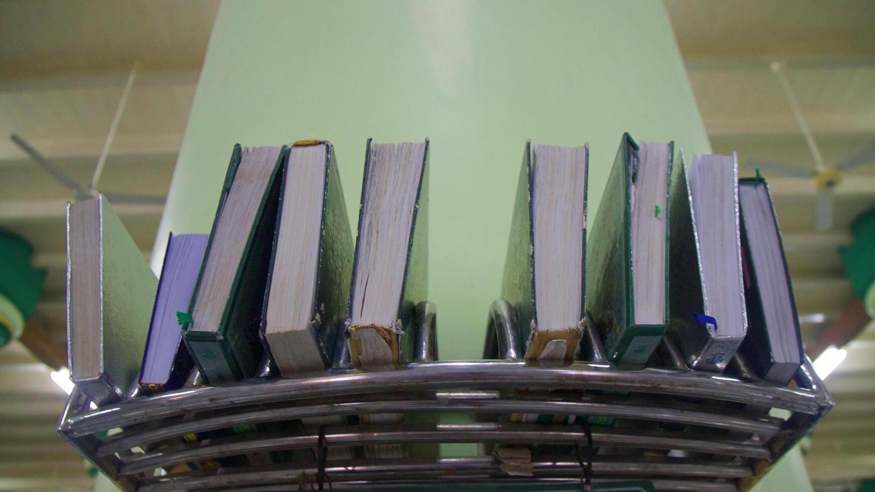 Rows of books of the Qur'an arranged in a mosque photo