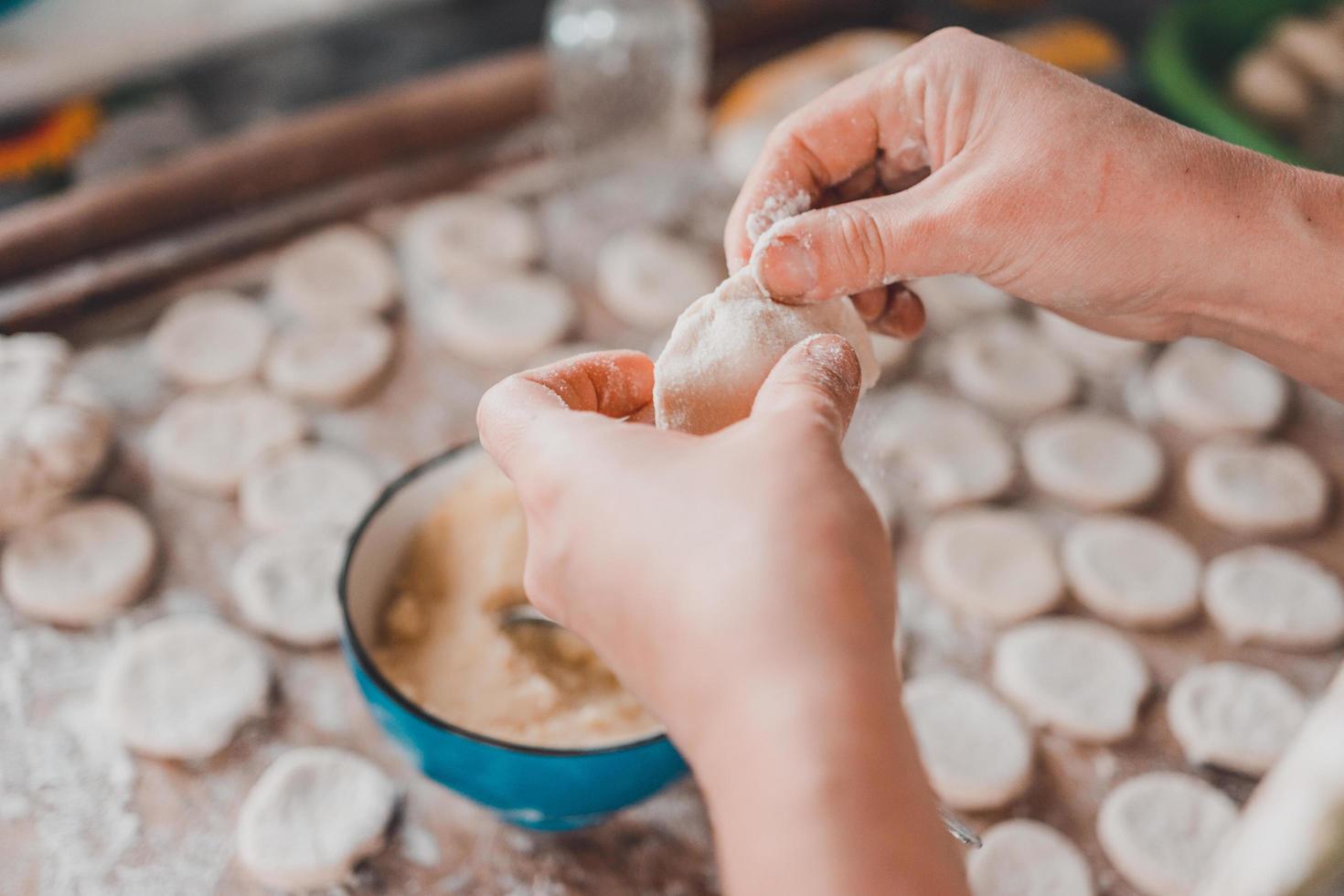 Mujer en la cocina prepara bolas de masa para el desayuno foto