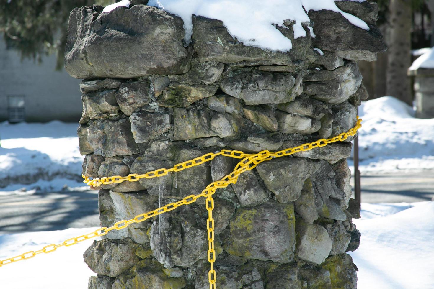 Yellow chain wrapped around a column of stones photo