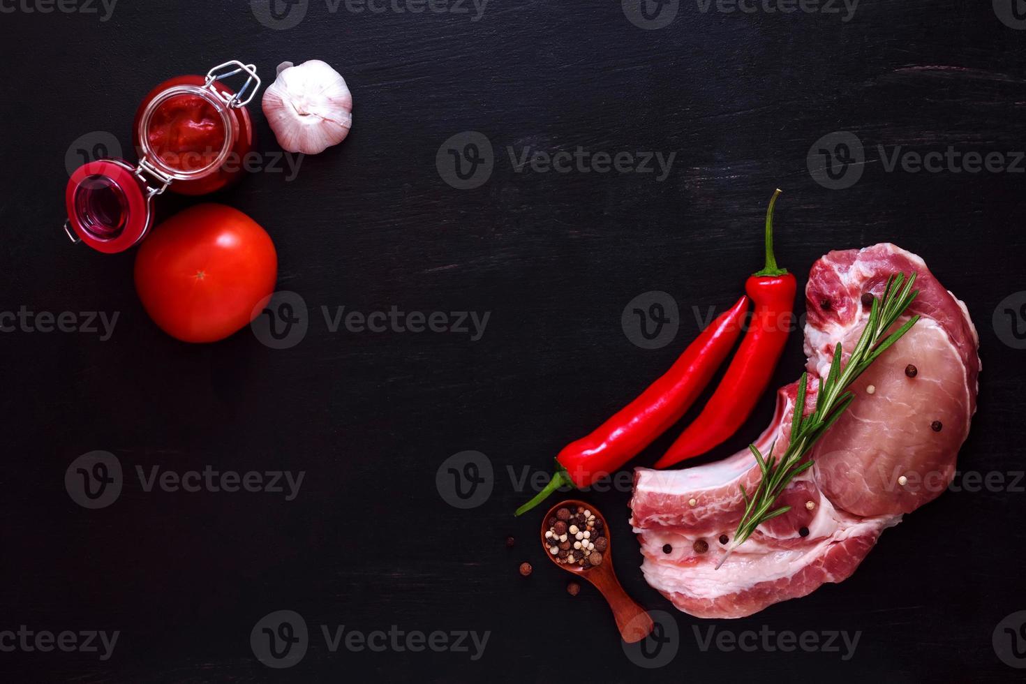 Pork entrecote raw meat with rosemary, pepper and red sauce photo
