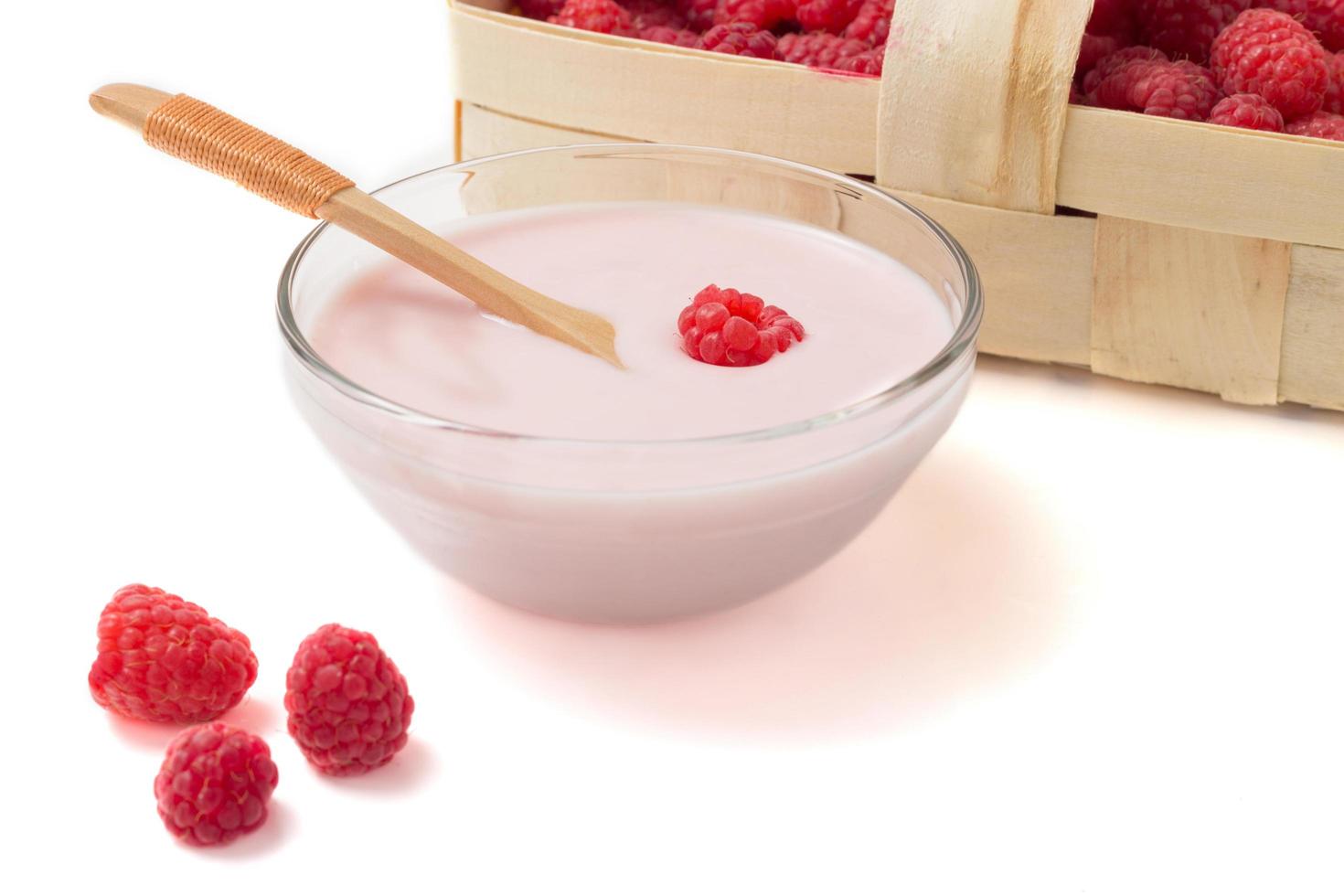 Raspberry yogurt in a glass cup with raspberry basket photo