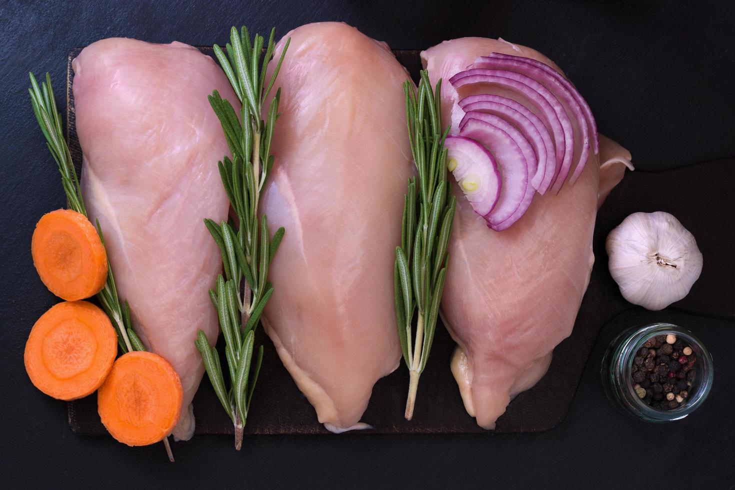 Fillet of chicken breast with rosemary, carrots, garlic and onions photo