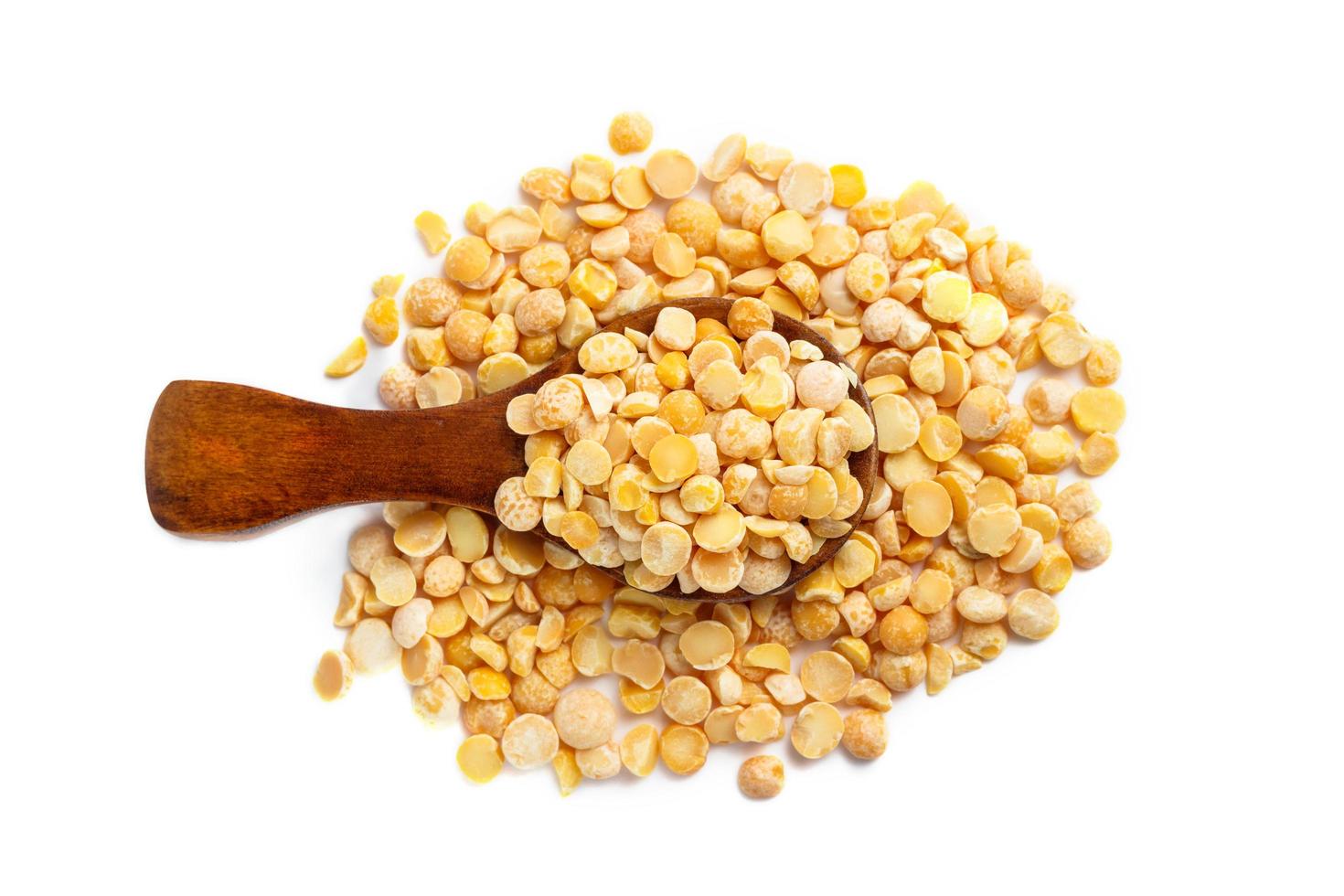 Dried yellow peas in wooden spoon isolated on white background photo