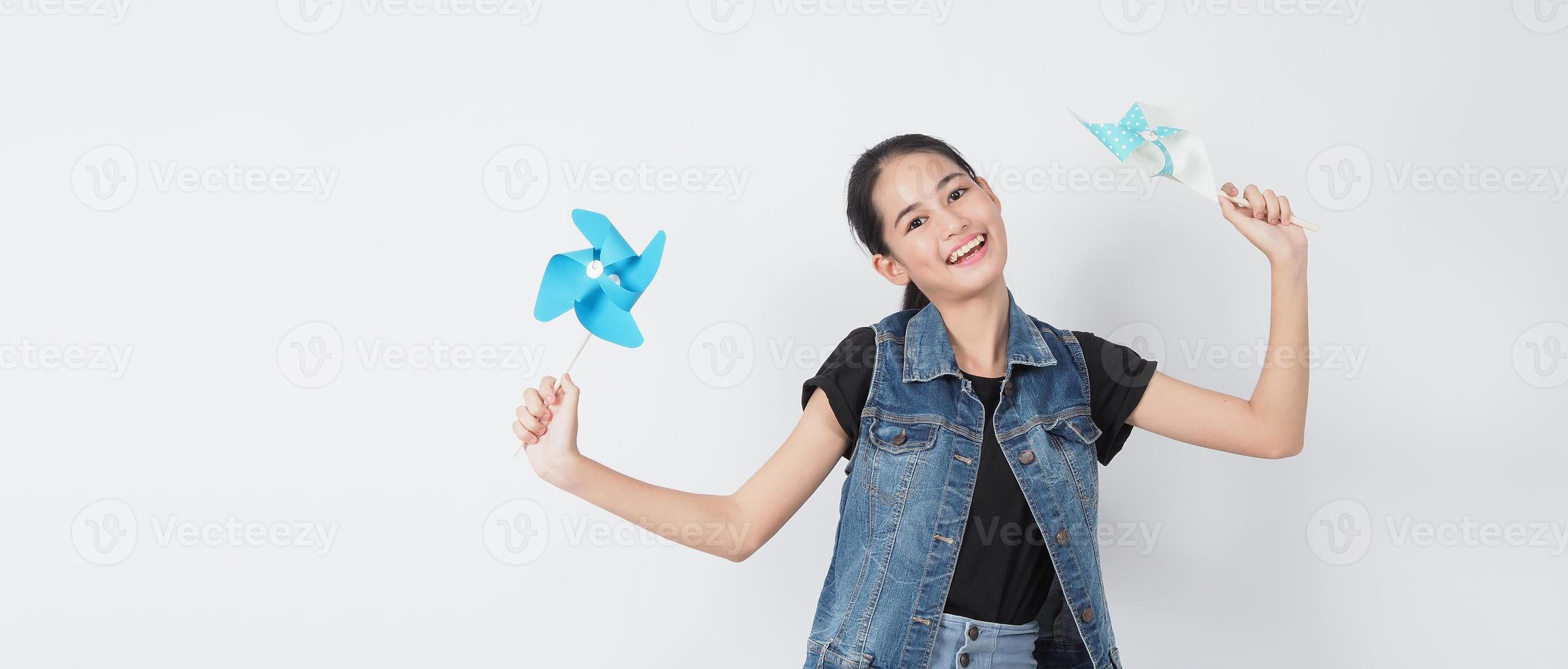 Teenage woman and paper windmill toys. teen with wind wheel stick photo