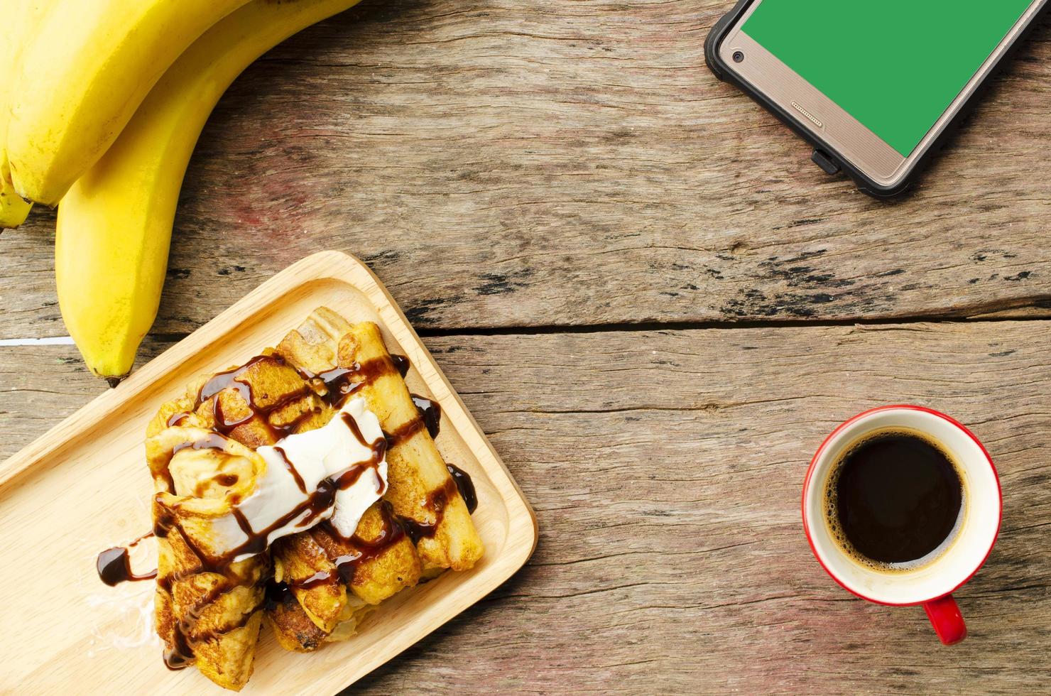 Banana french toast and Black coffee red cup and smartphone photo