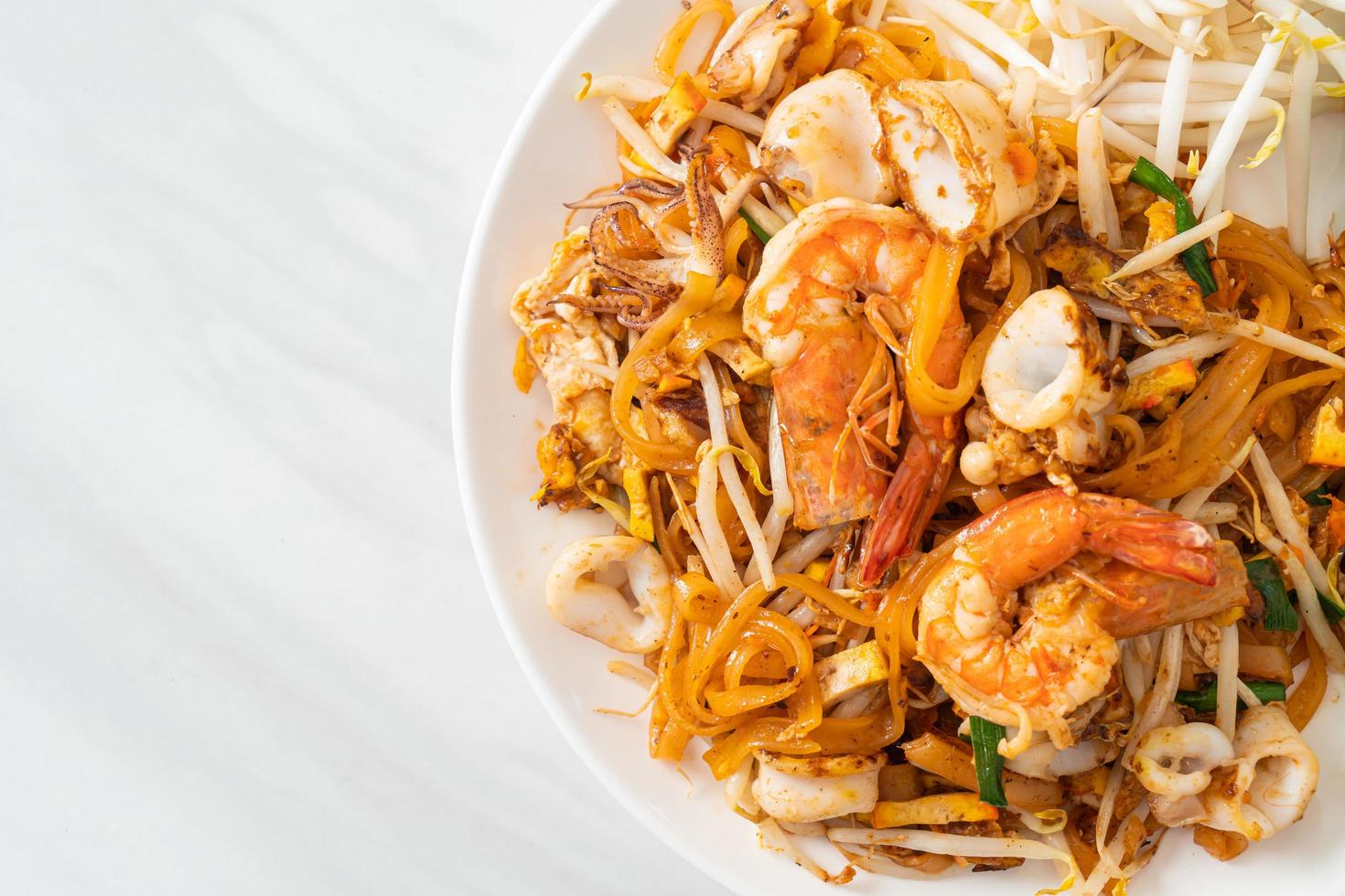 Stir fried noodles with shrimps, squid or octopus and tofu photo