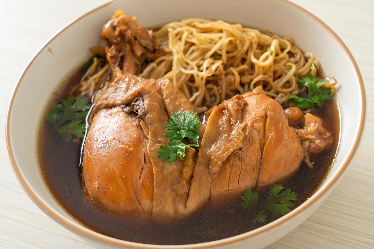 fideos con pollo a la brasa en sopa marrón foto