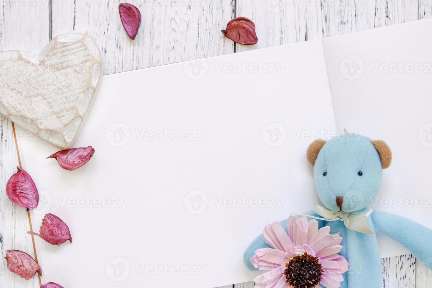 Paper with toy, heart, flower and petals photo