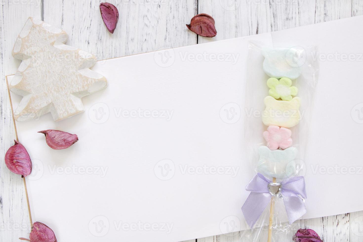 Paper with candy, petals, and tree photo