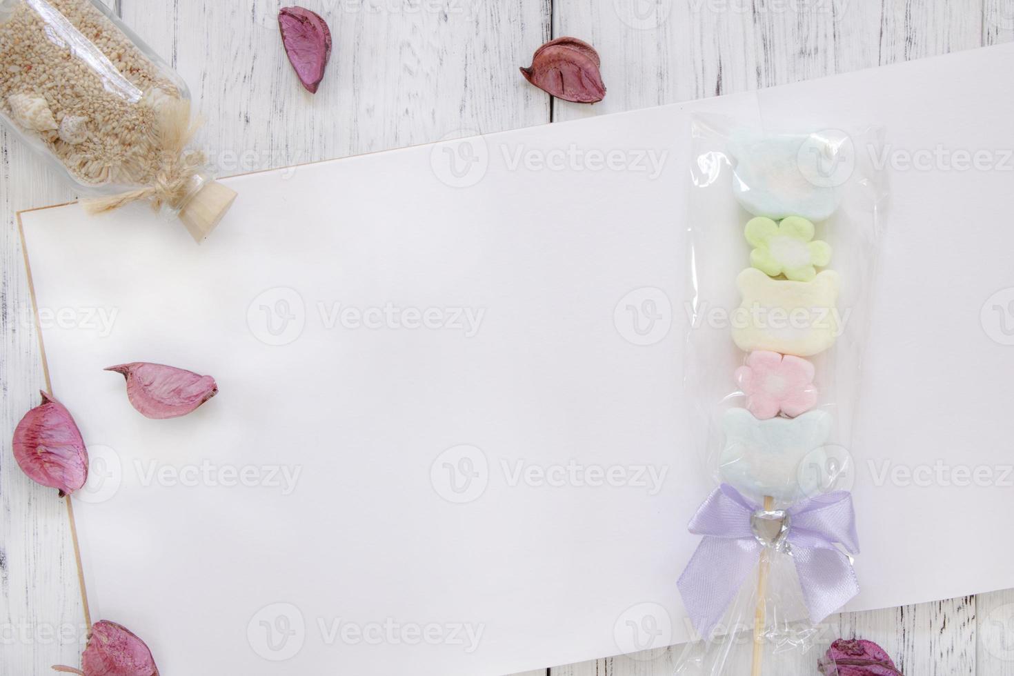 Paper with candy and petals photo