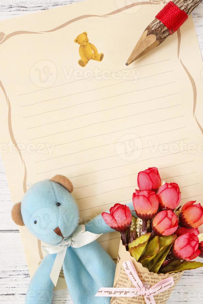 Paper with pencil, flowers and toy photo