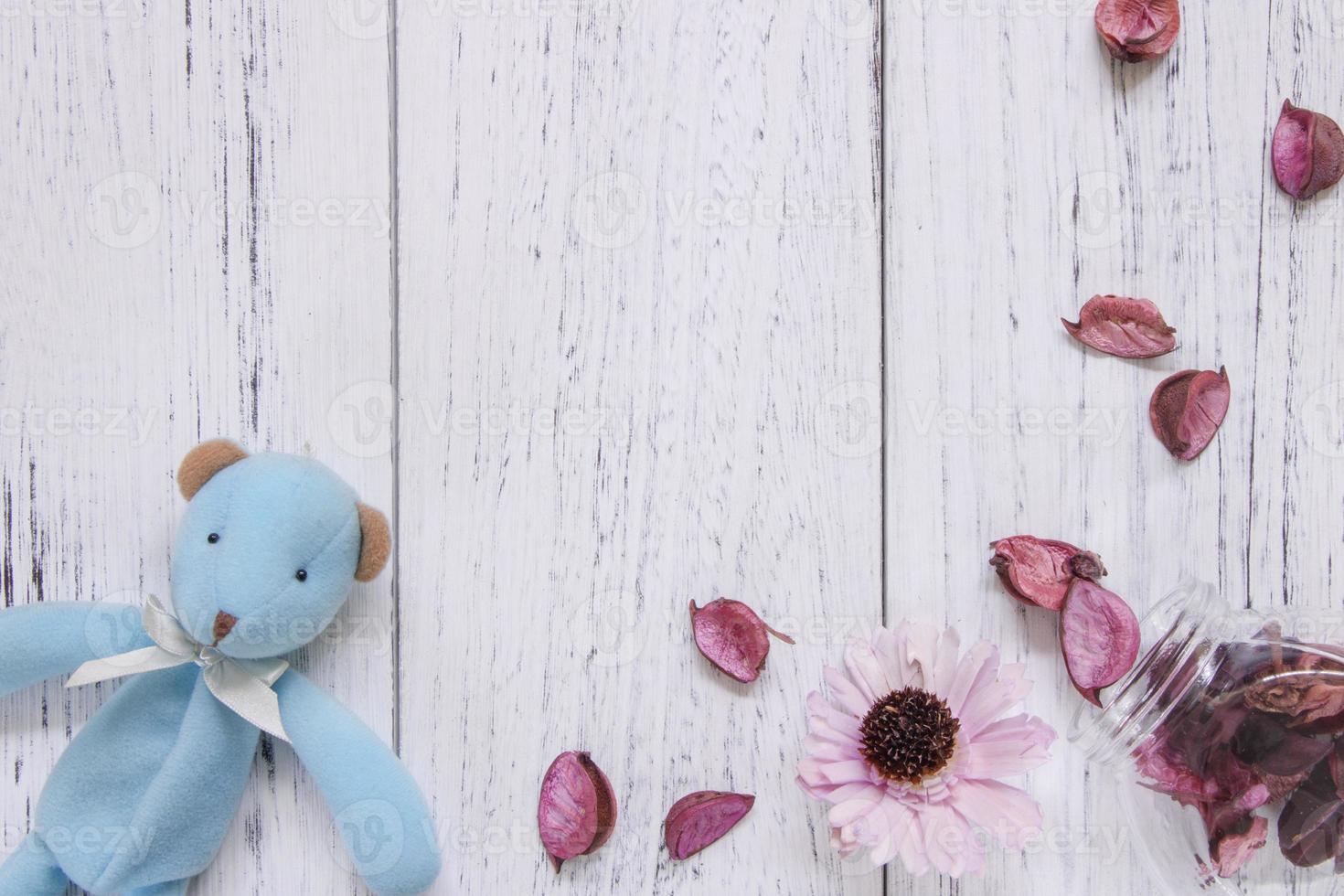 Toy and petals on white wood photo