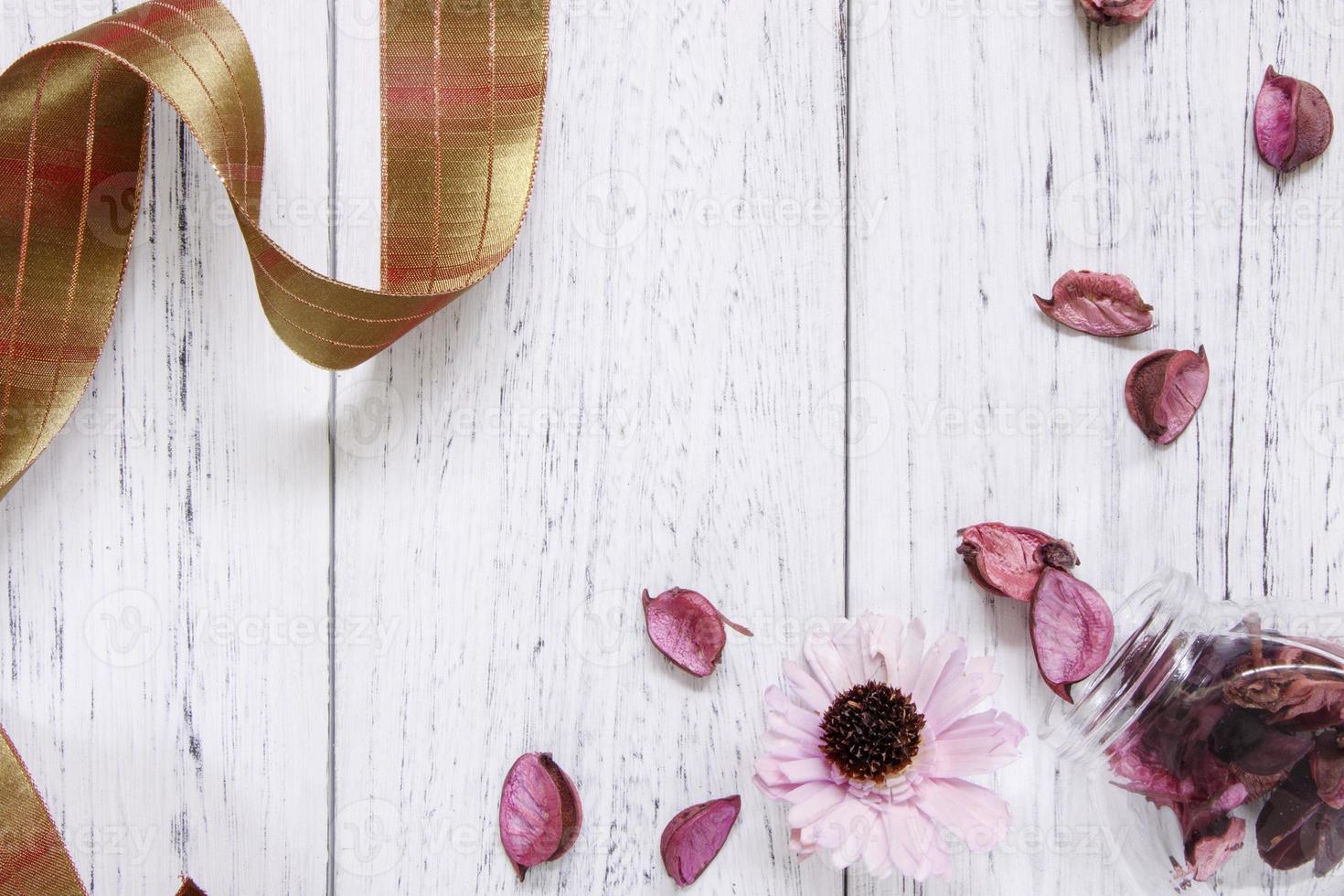 Petals and ribbon on white wood photo