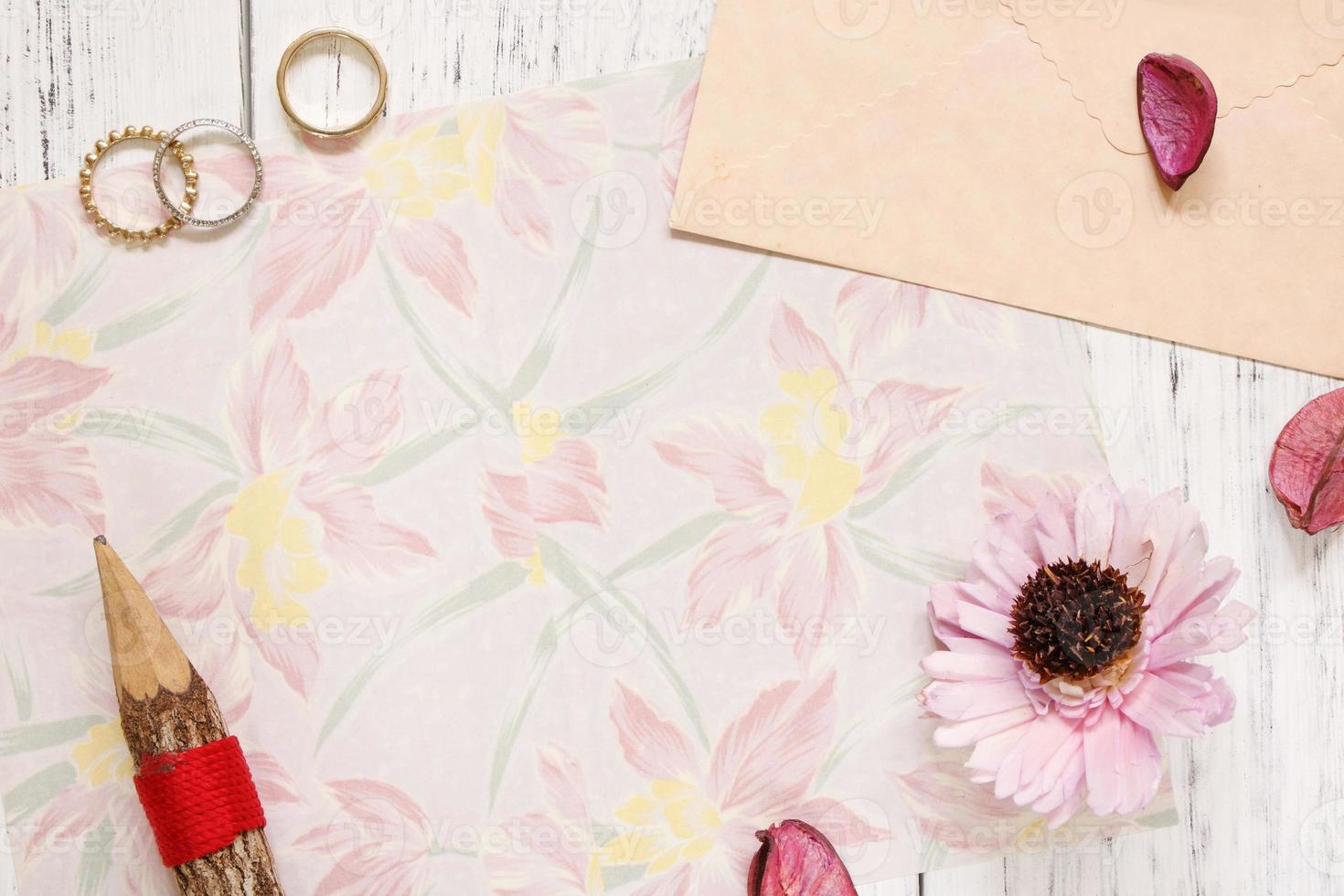 Floral paper with rings, pencil and flower photo