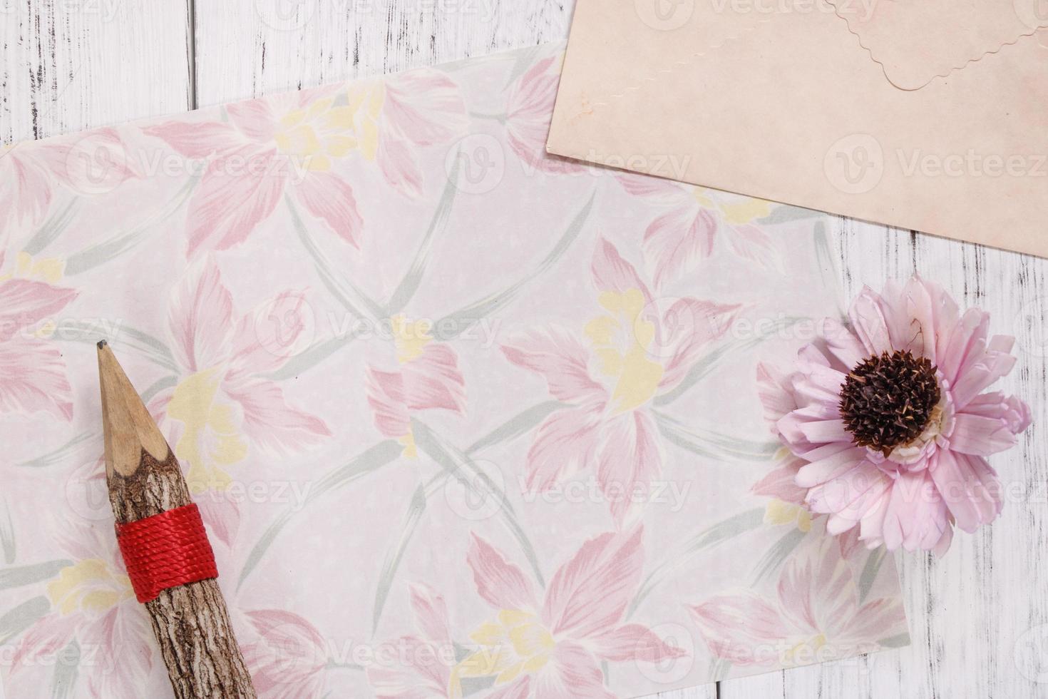papel floral con lápiz y flor foto