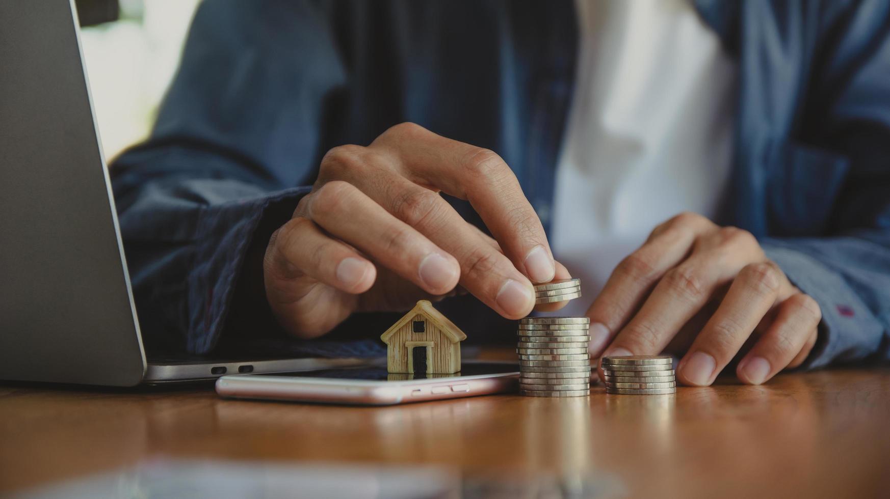 Mano contando la pila de monedas sobre la mesa de madera foto