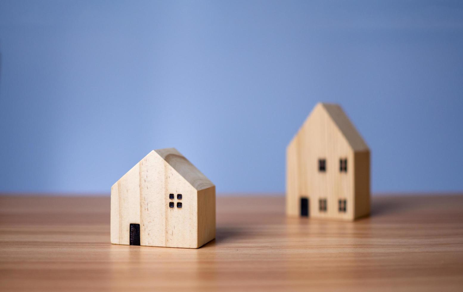 Two wooden model houses placed on a wooden table. photo