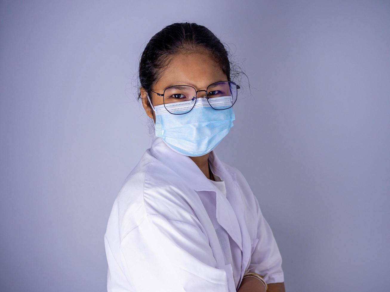 Portrait of a female doctor wearing a mask and wearing glasses. photo