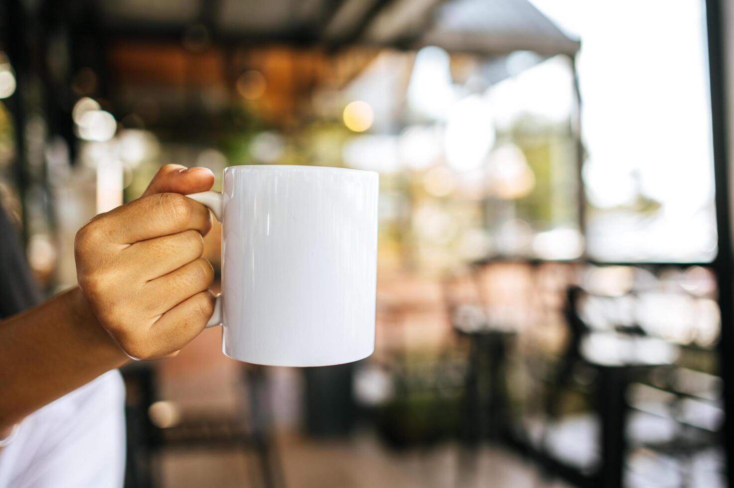 taza blanca en la mano en tiempo de relajación foto