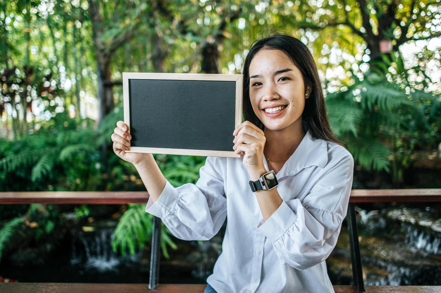 hand woman holding black board in the garden photo
