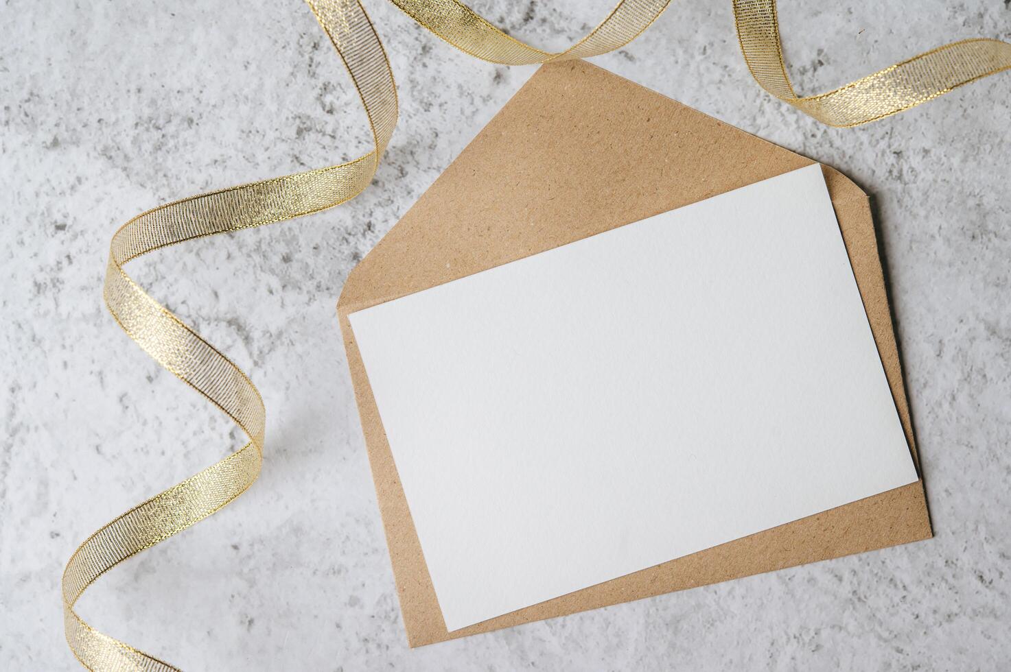 A blank card with envelope and leaf is placed on white background photo