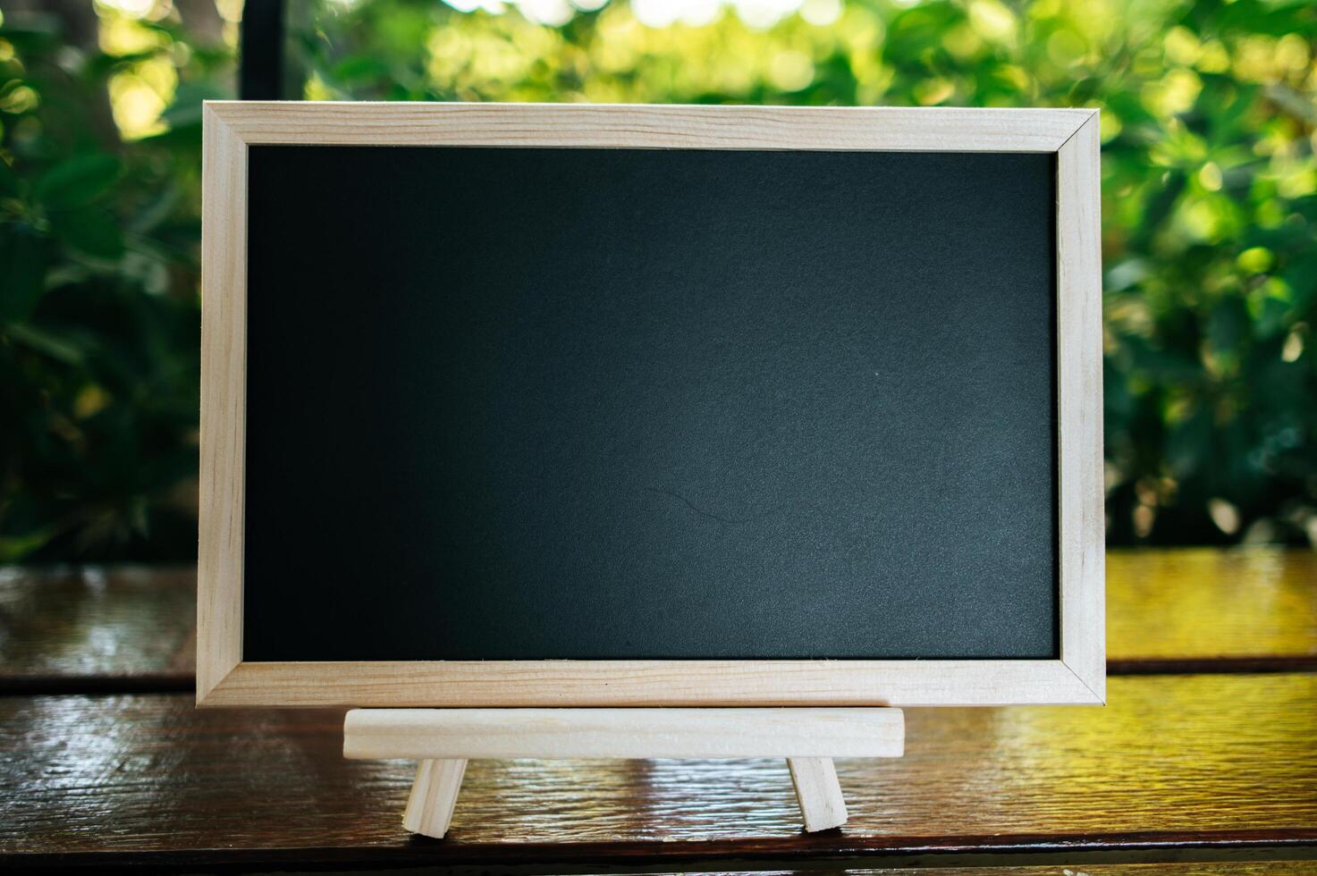 chalkboard with standy on the table in garden photo