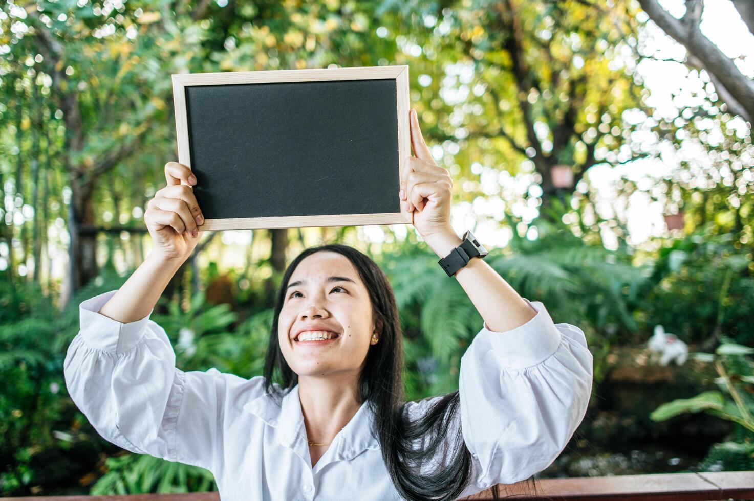 hand woman holding black board in the garden photo