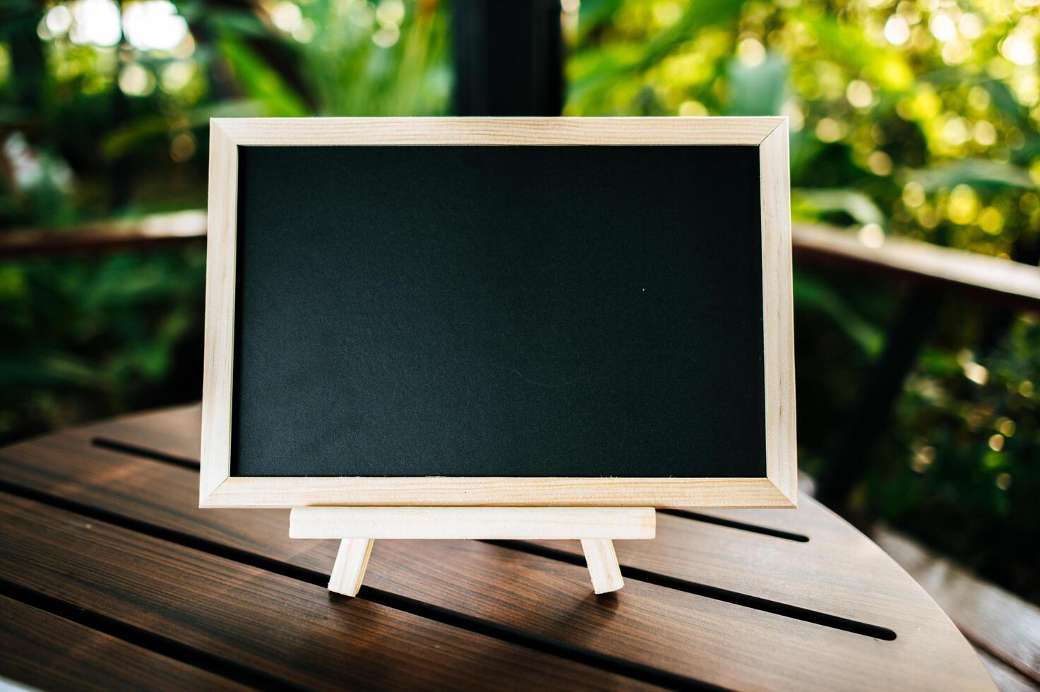 chalkboard with standy on the table in garden photo