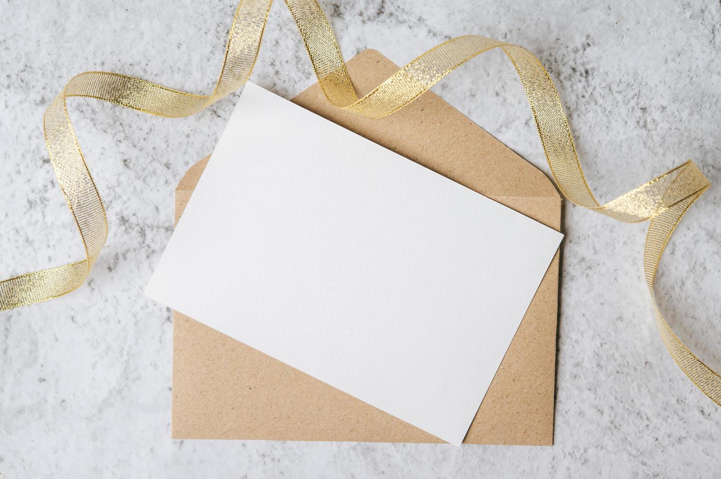 A blank card with envelope and leaf is placed on white background photo