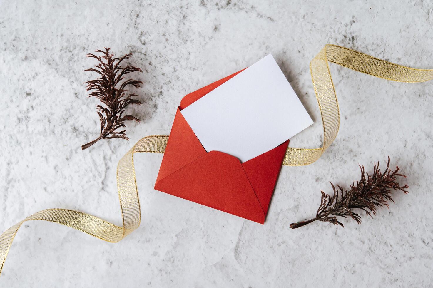 A blank card with red envelope and leaf is placed on white background photo