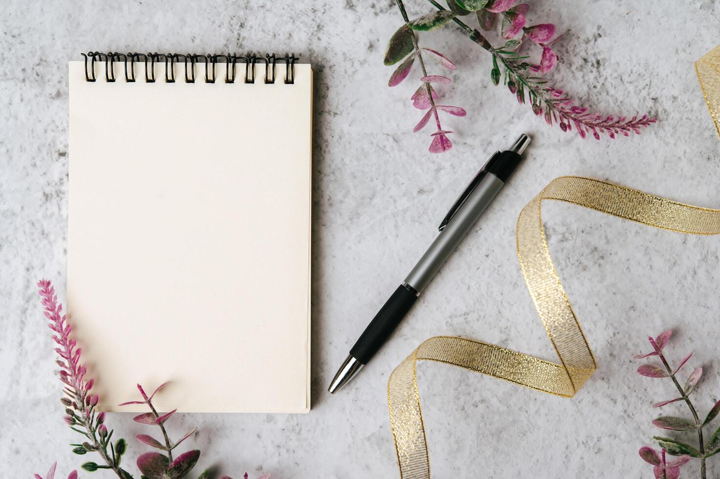 notebook, pen and flower is placed on white background photo