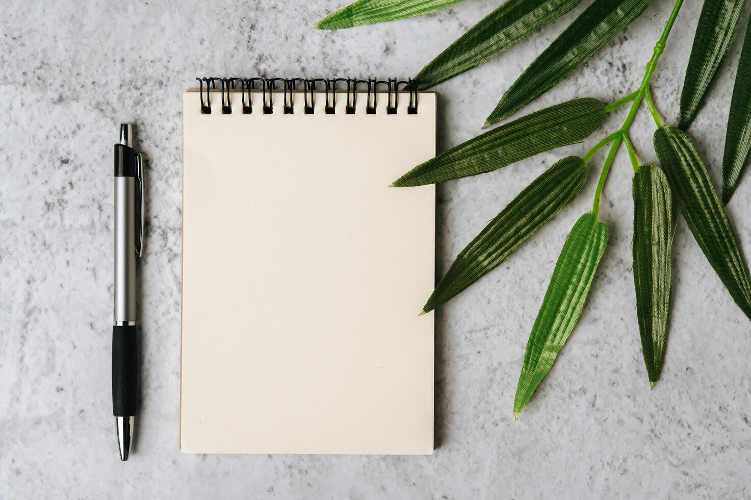 notebook, pen and flower is placed on white background photo
