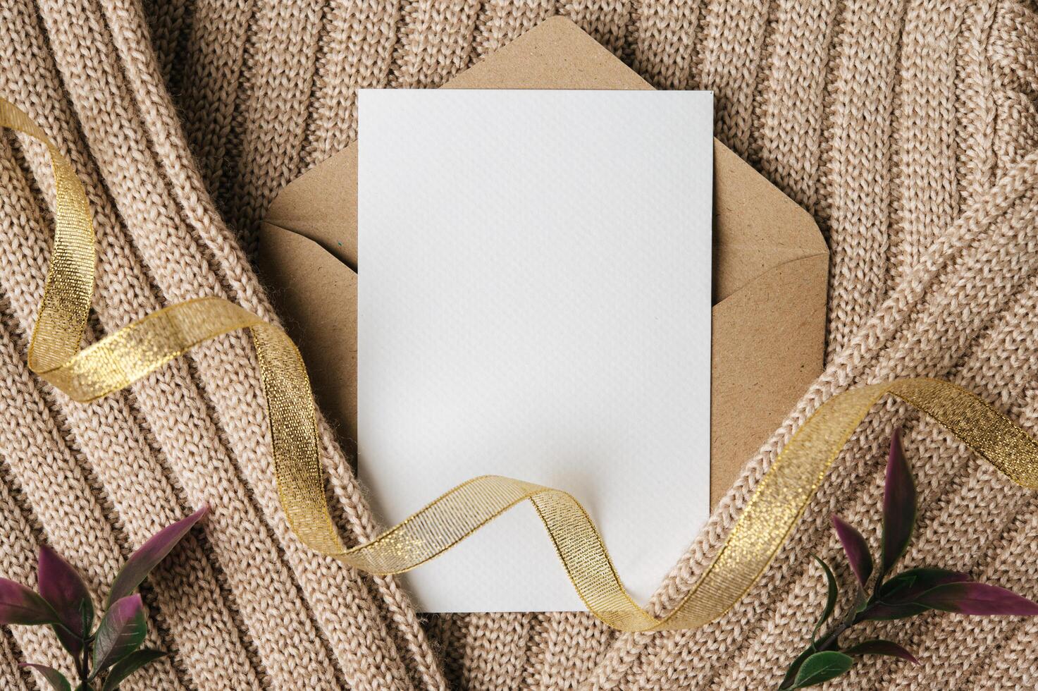 A blank card is placed on envelope and a sweater photo