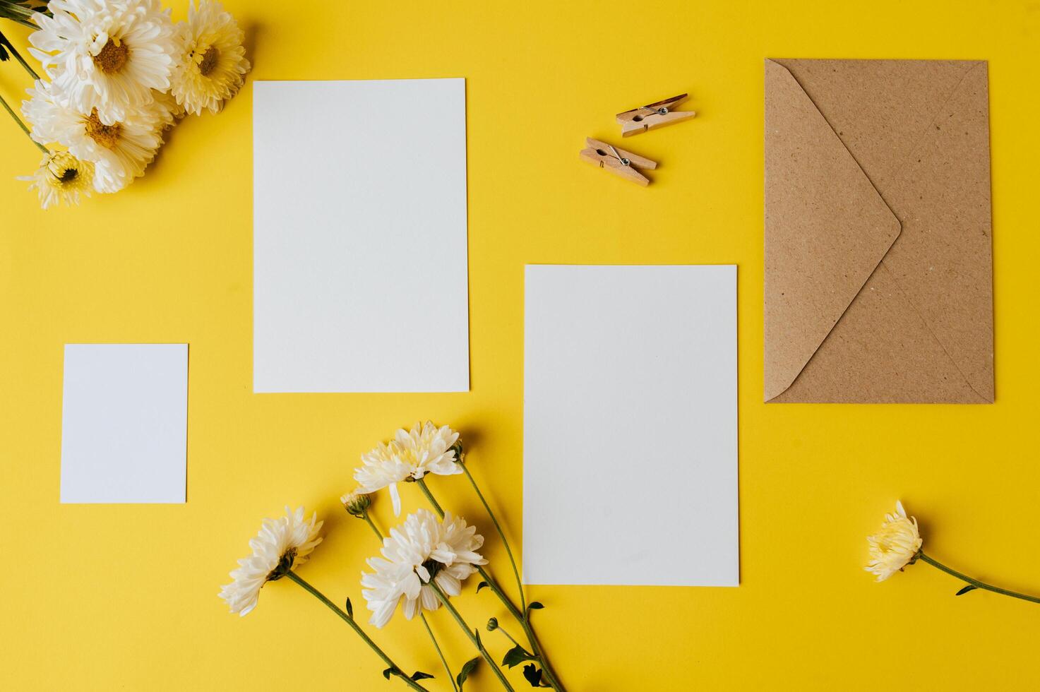 blank card with envelope and flower is placed on yellow background photo