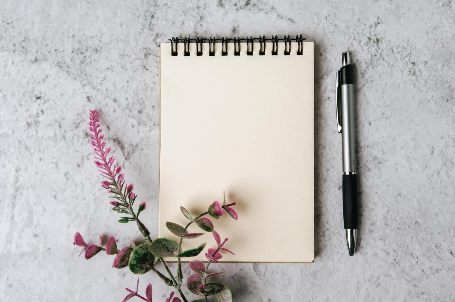 notebook, pen and flower is placed on white background photo