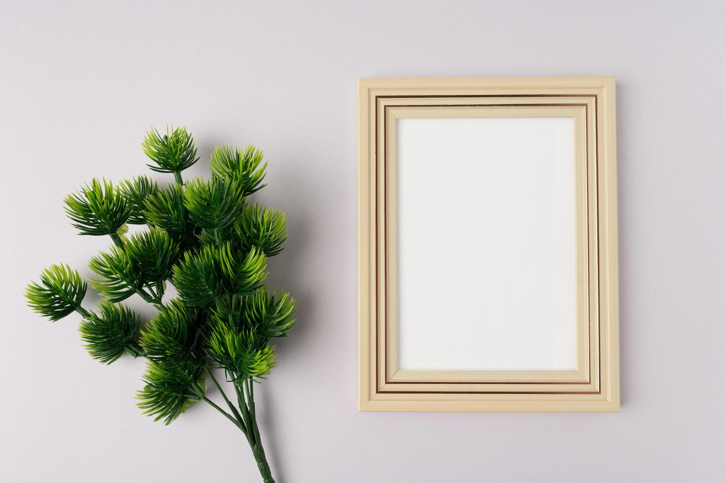 white photo frame and leaf branches on white background