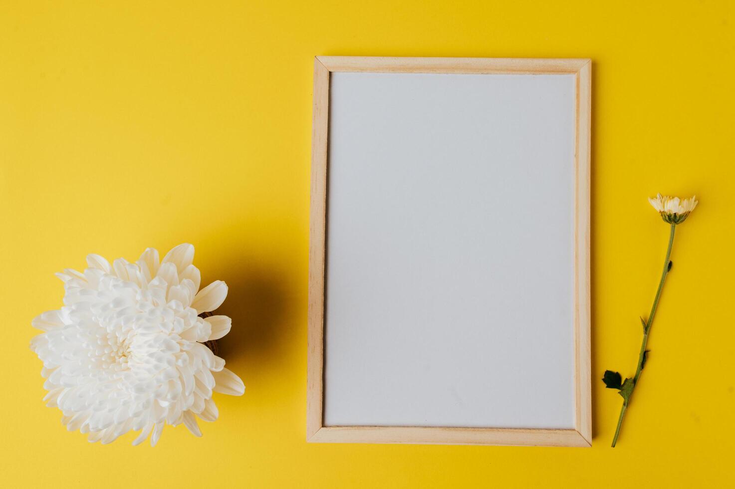 White board and flower is placed on yellow background photo