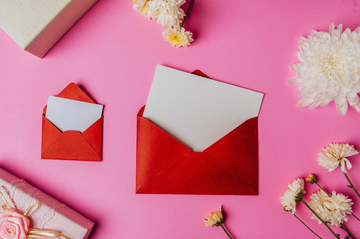 sobre rojo, caja de regalo rosa con tarjeta en blanco y flor rosa foto