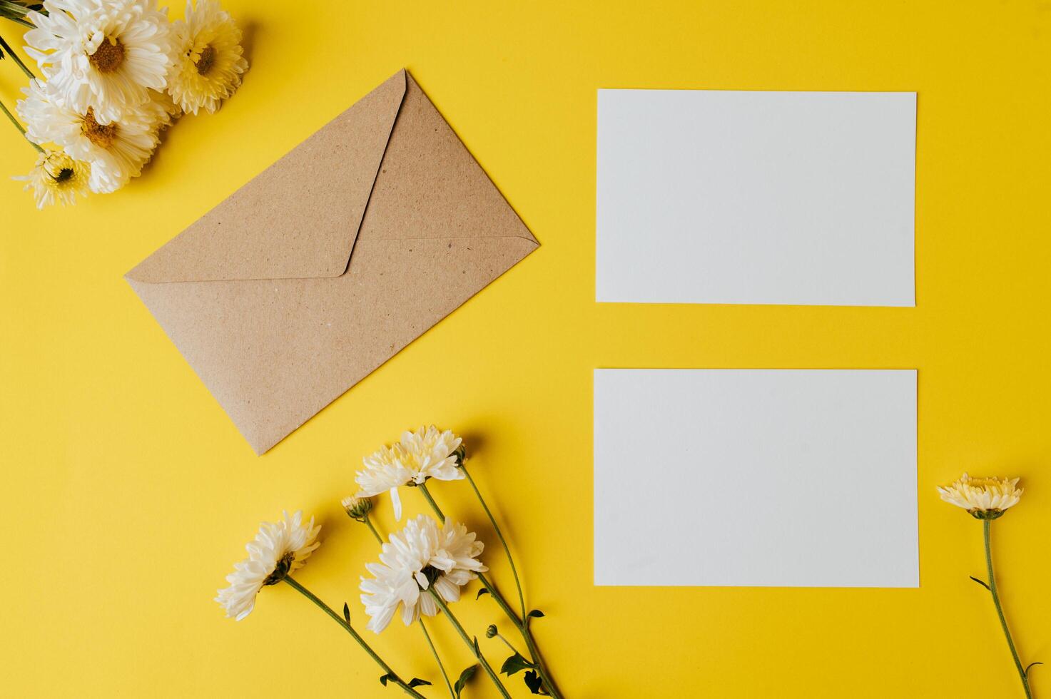 blank card with envelope and flower is placed on yellow background photo