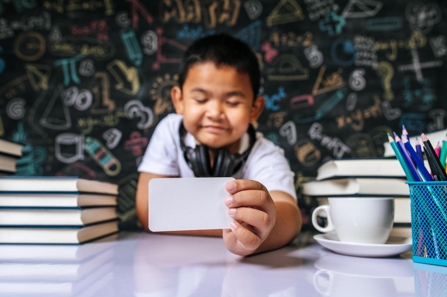 Child acting with blank card in the classroom photo