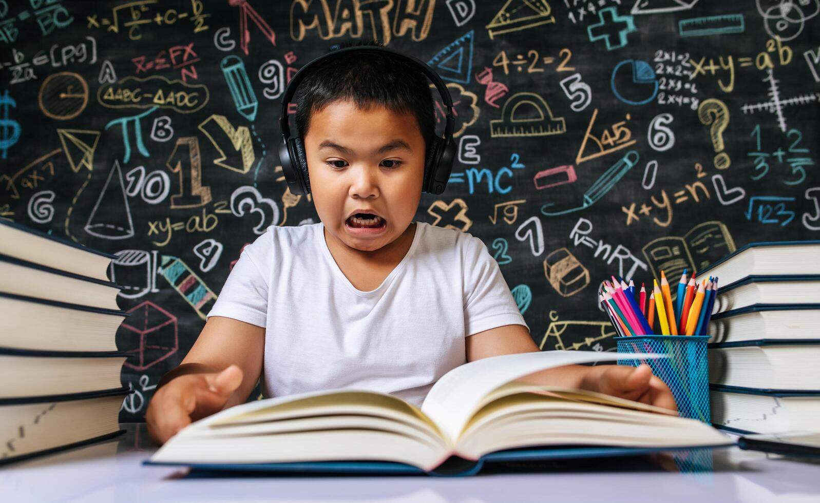 Child sitting and reading book in the classroom photo