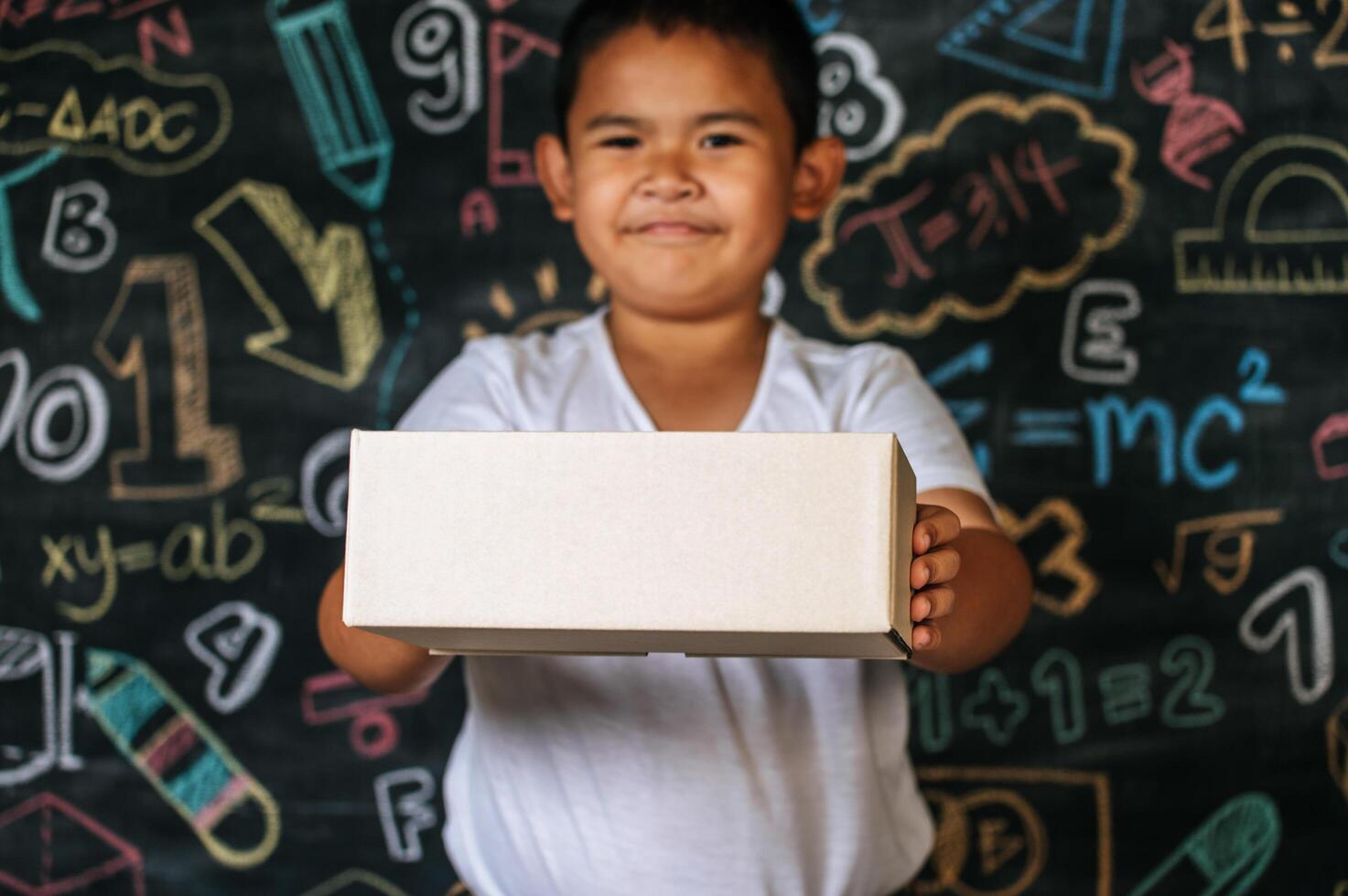 niño sosteniendo la caja en el aula foto