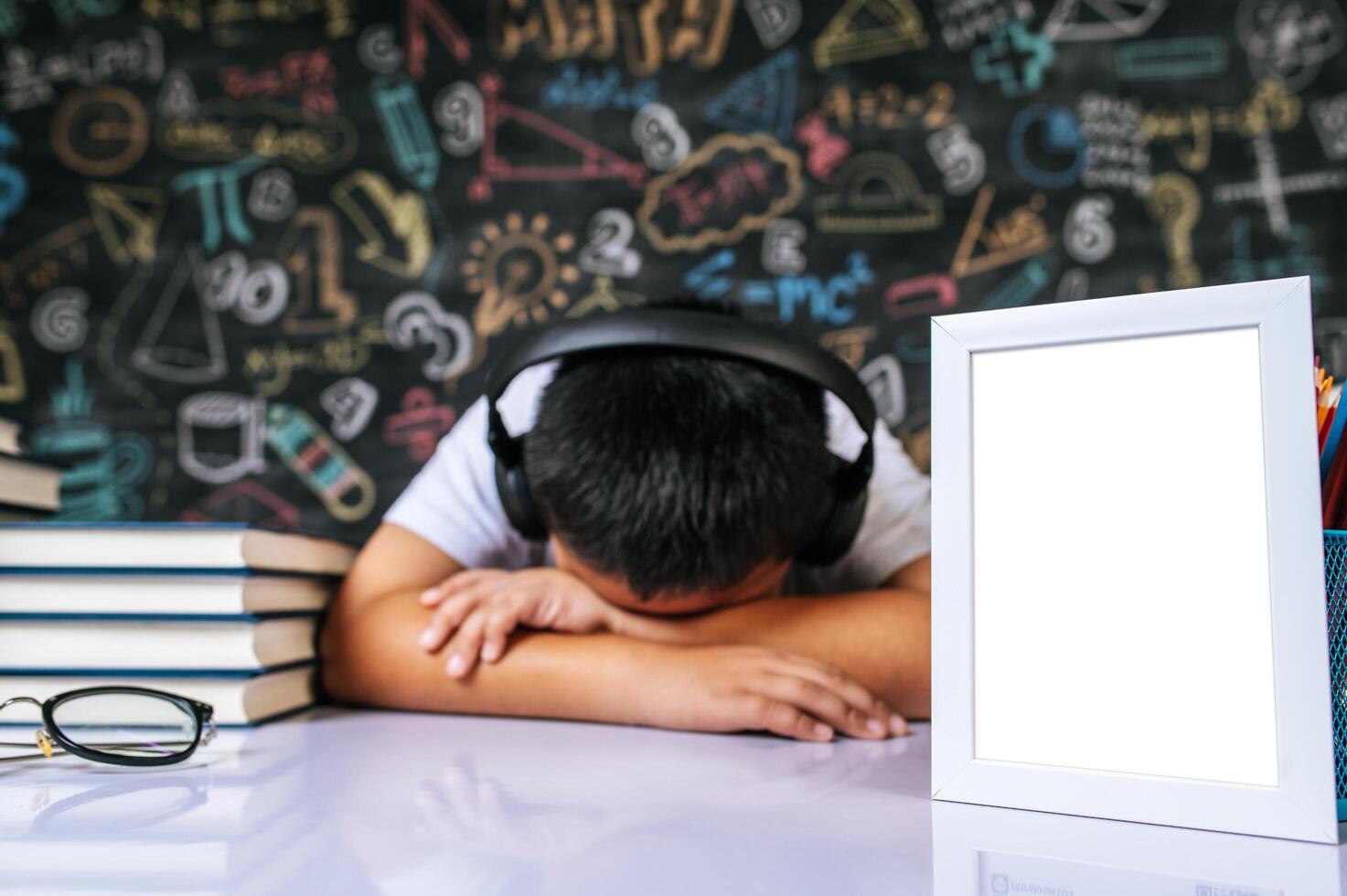 Child sitting and sleeping with photo frame in the classroom