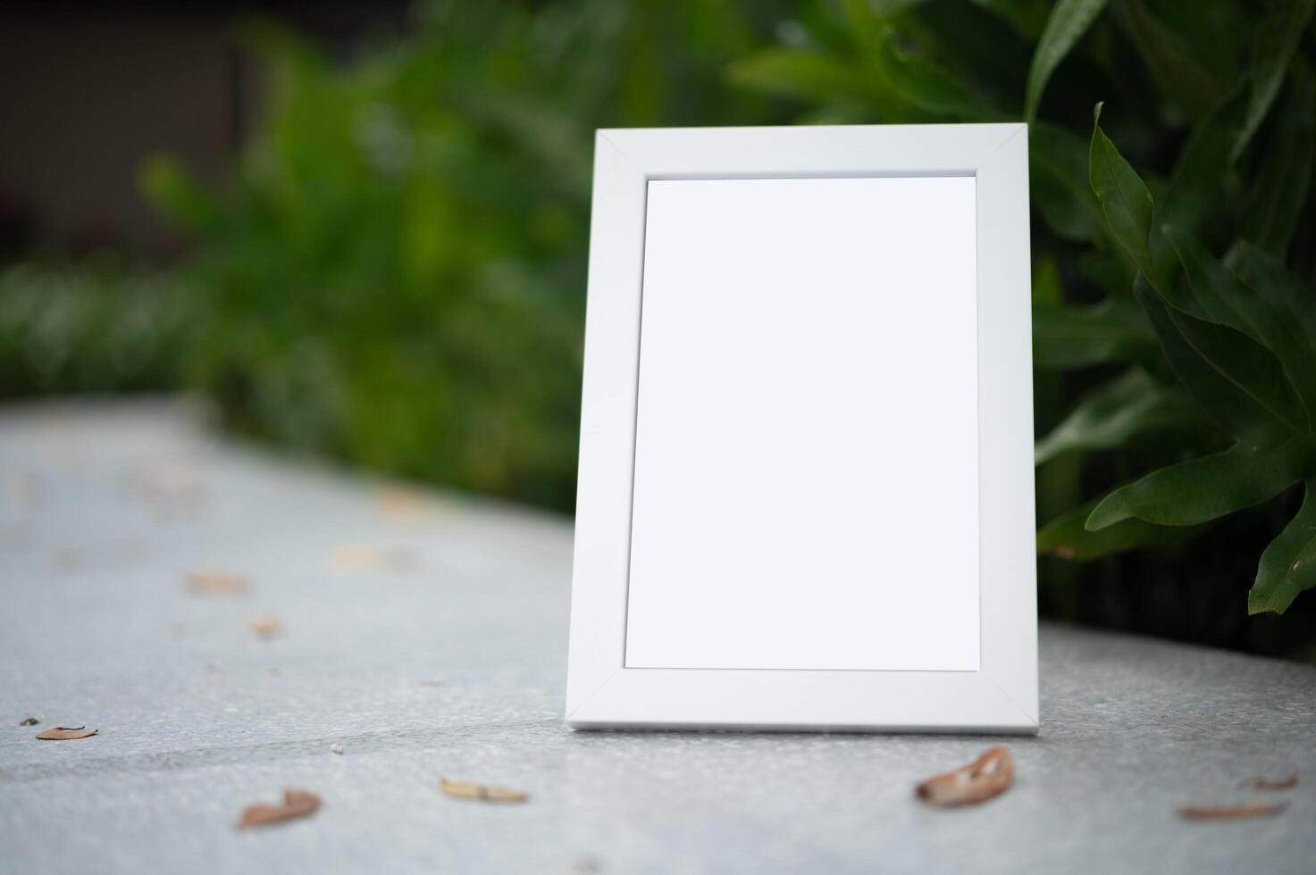 The picture frame is placed on the cement table. photo